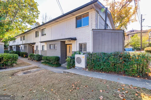 a view of a house with a yard and table and chairs under an umbrella