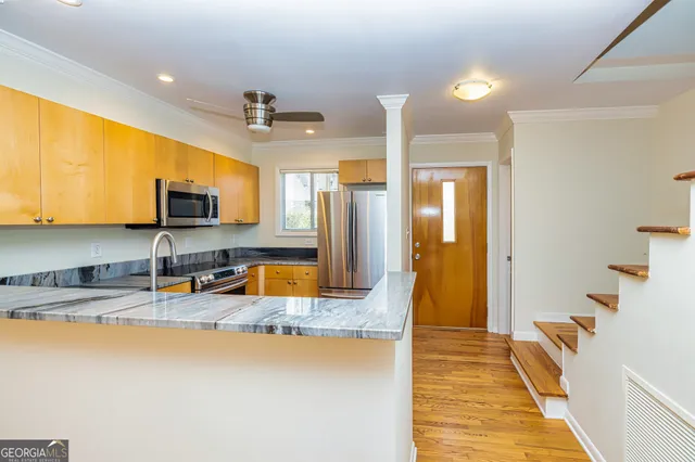 a kitchen with stainless steel appliances granite countertop a sink a stove and a refrigerator