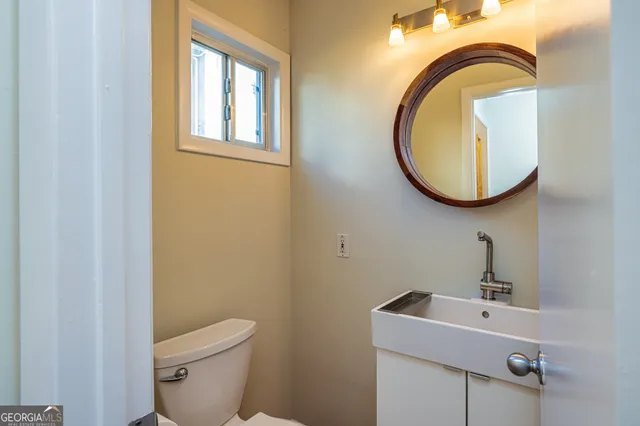 a bathroom with a sink mirror and toilet