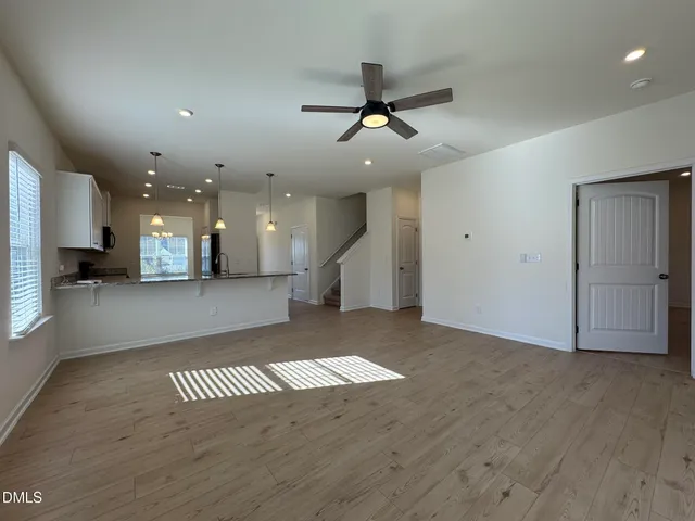 wooden floor in an empty room with a kitchen