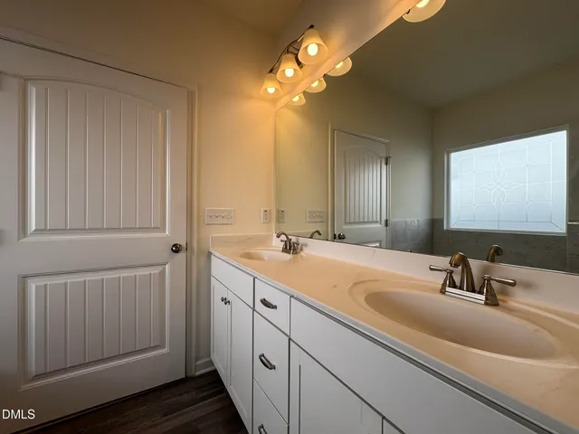 a bathroom with a double vanity sink and a mirror