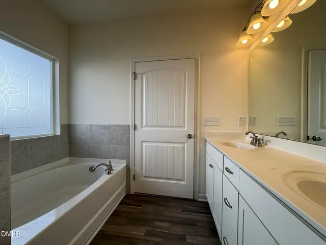 a bathroom with a tub sink and mirror