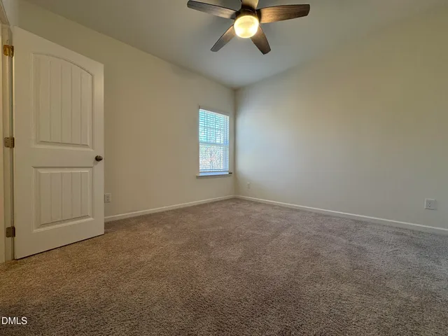 an empty room with a chandelier fan