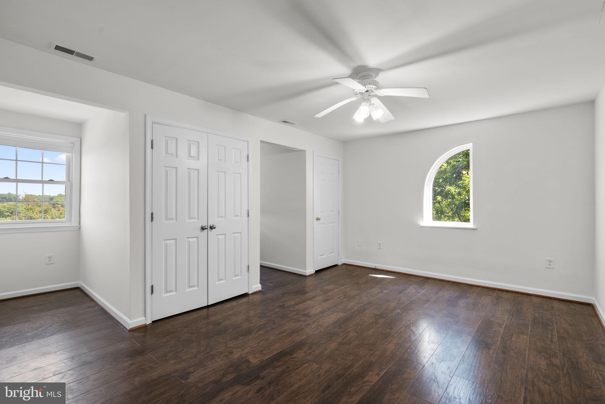 24000 Clarksburg Road Clarksburg, MD 20871 - Photo 36 of 60 an empty room with wooden floor chandelier fan and windows