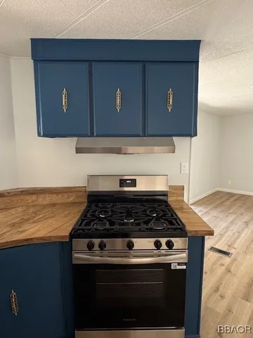 a kitchen with granite countertop stainless steel appliances a stove and a microwave