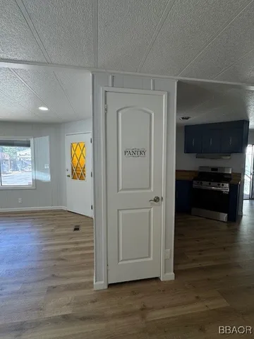 an empty room with wooden floor fireplace and windows