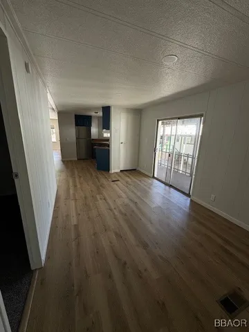 a view of a hallway to a room with wooden floor and stairs