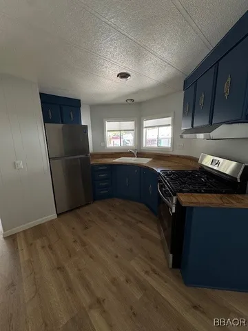 a kitchen with granite countertop stainless steel appliances a refrigerator a sink and a stove