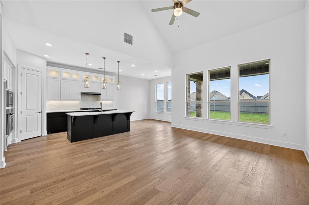 3776 Jane Street Venus, TX 76084 - Photo 8 of 25 a large kitchen with stainless steel appliances kitchen island a large counter top and wooden floors