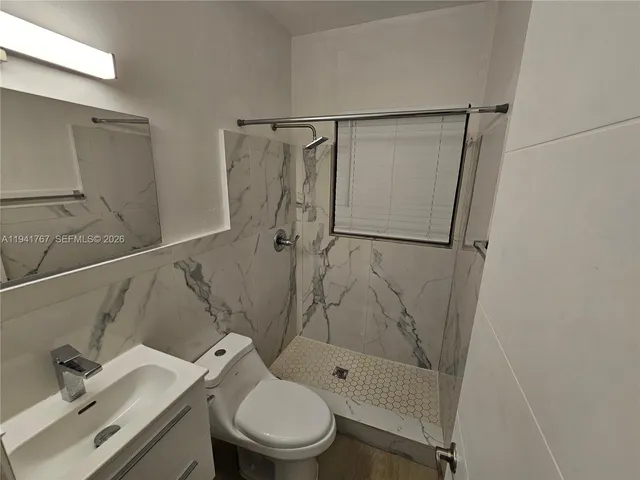 a bathroom with a shower toilet and sink