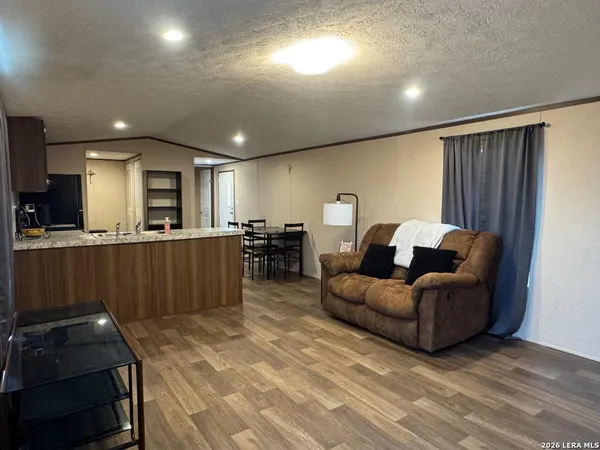 a living room with furniture and kitchen view