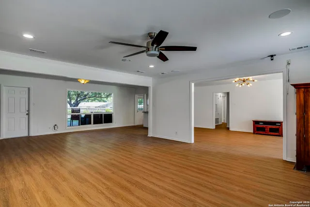 an empty room with kitchen fireplace and windows