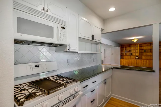 a kitchen with granite countertop a stove and a sink
