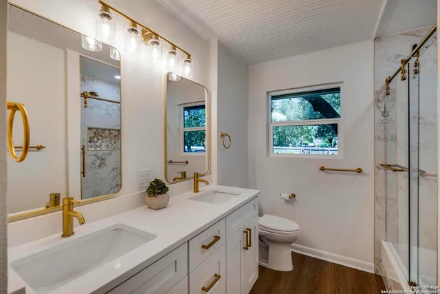a bathroom with a granite countertop sink toilet and shower