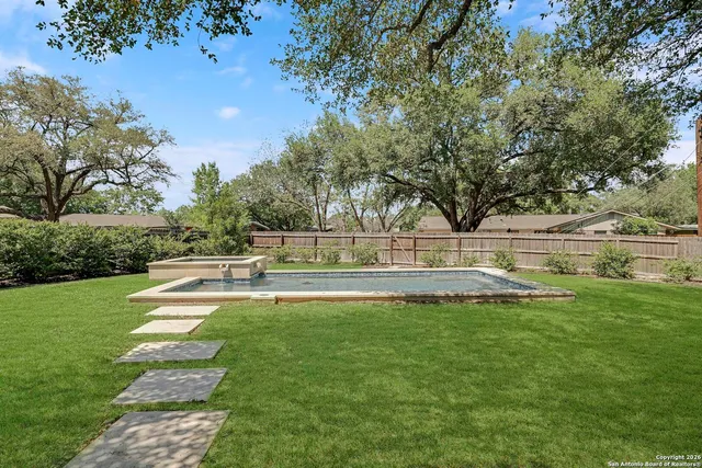 a view of swimming pool with trees and green space