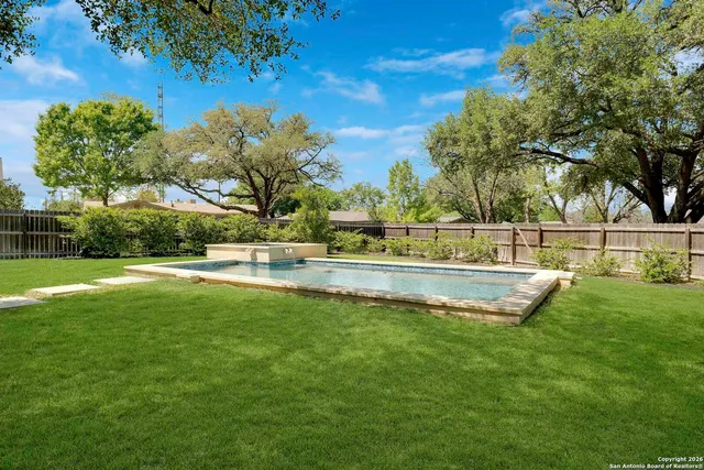 a view of yard with swimming pool and green space