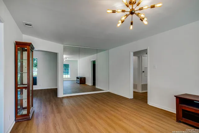 a view of empty room with wooden floor