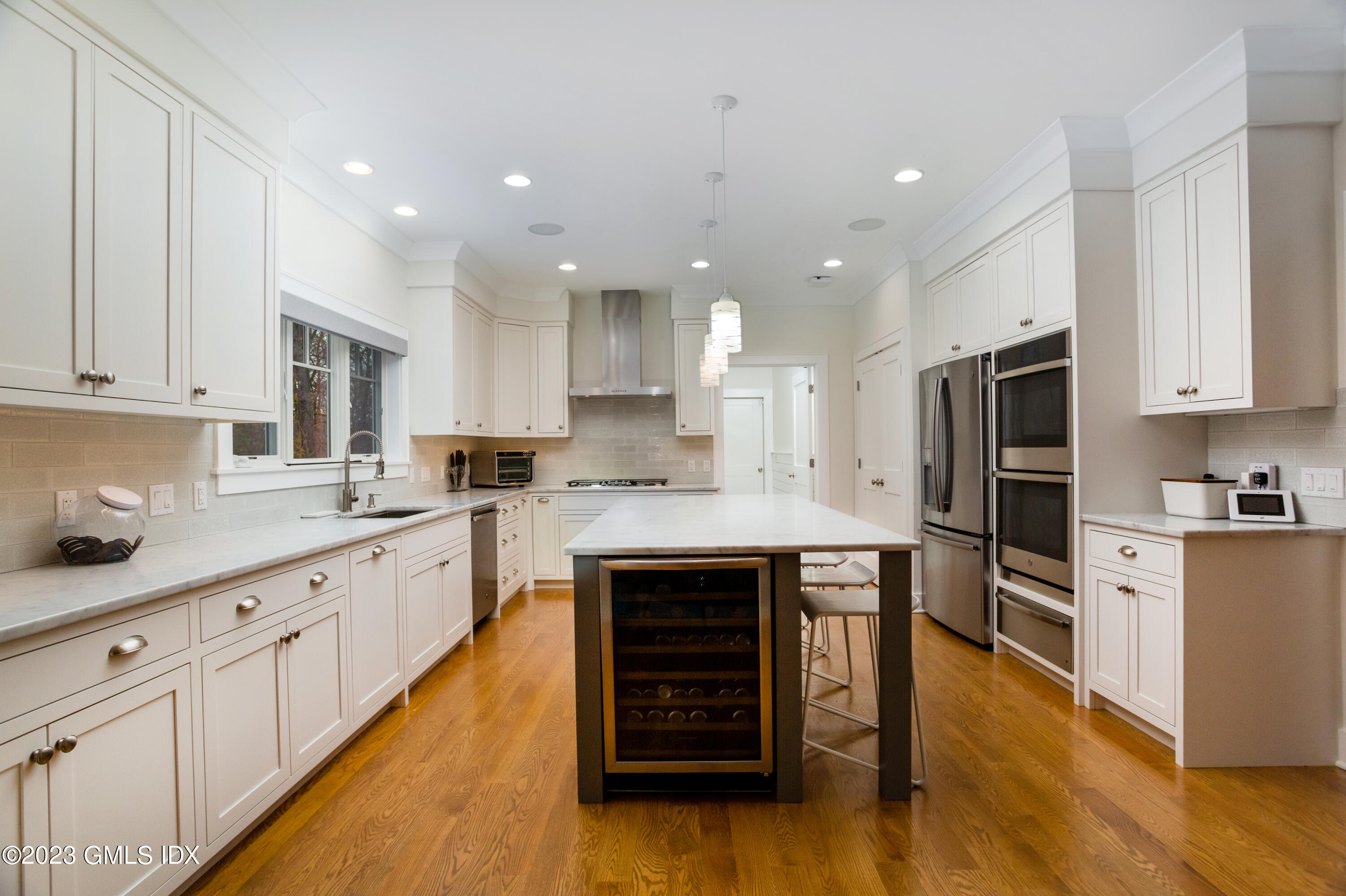 9 Cottontail Road Cos Cob, CT 06807 - Photo 7 of 33 a kitchen with stainless steel appliances granite countertop a stove top oven a sink dishwasher and a refrigerator with wooden floor