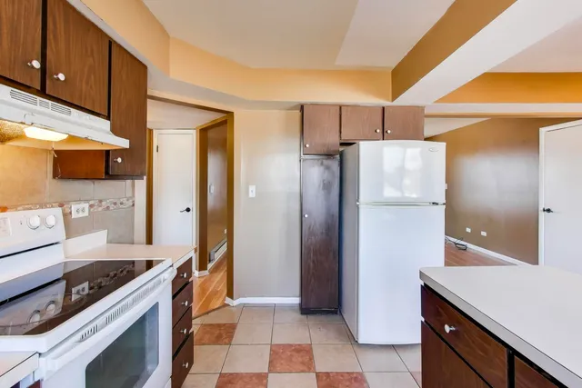 a kitchen with stainless steel appliances granite countertop a refrigerator and a stove