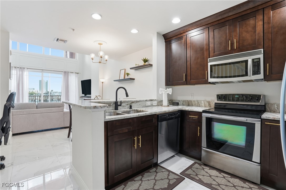2743 First Street, Unit 109 Fort Myers, FL 33916 - Photo 13 of 27 a kitchen with stainless steel appliances granite countertop a stove a sink and a microwave