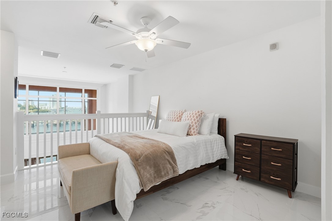 2743 First Street, Unit 109 Fort Myers, FL 33916 - Photo 18 of 27 a bedroom with a bed a large window and a chandelier