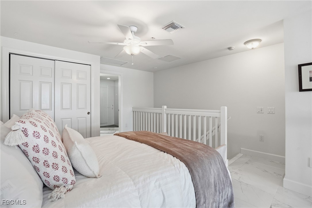 2743 First Street, Unit 109 Fort Myers, FL 33916 - Photo 21 of 27 a bedroom with a large bed and a chandelier