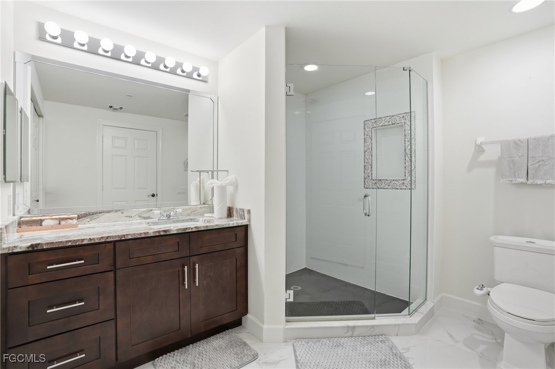 2743 First Street, Unit 109 Fort Myers, FL 33916 - Photo 23 of 27 a bathroom with a granite countertop sink mirror and toilet
