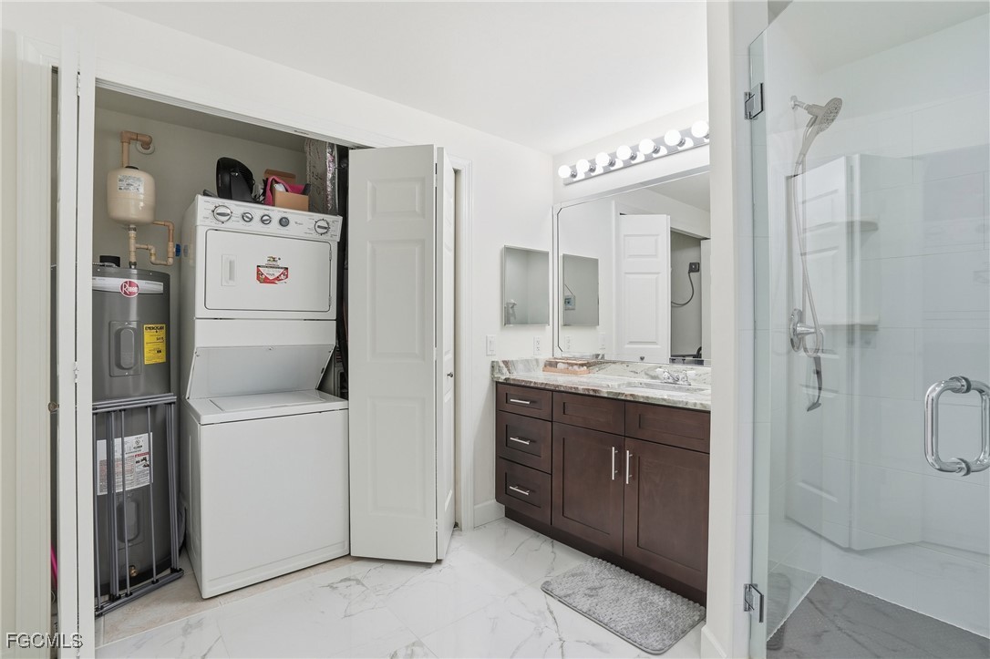 2743 First Street, Unit 109 Fort Myers, FL 33916 - Photo 24 of 27 a utility room with cabinets washer and dryer