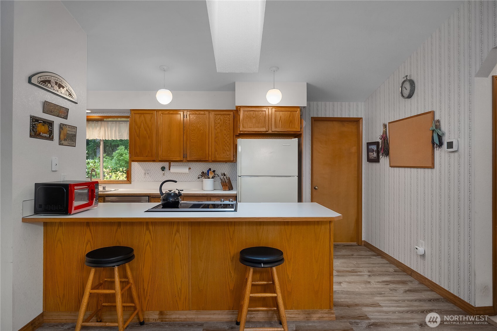 5505 Oyster Bay Road Northwest Olympia, WA 98502 - Photo 8 of 40 a kitchen with stainless steel appliances a sink cabinets and wooden floor