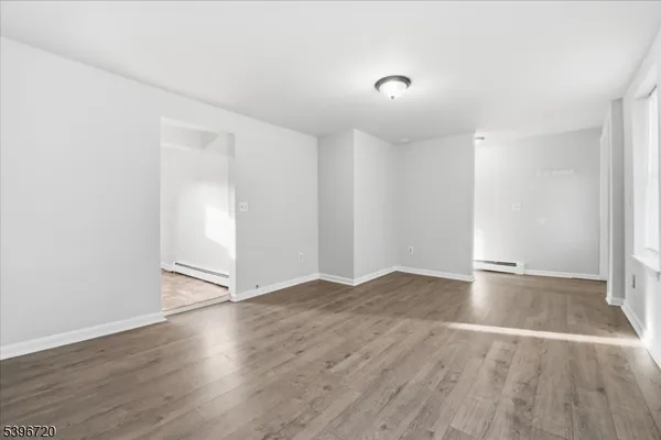 an empty room with wooden floor and white walls