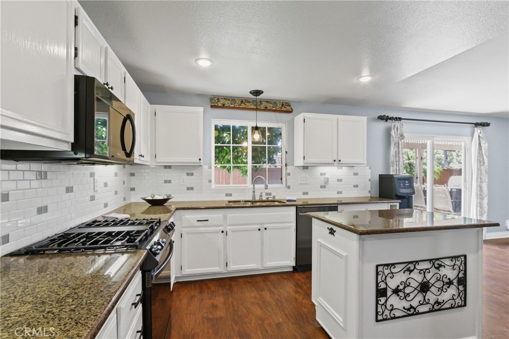 42005 Pine Needle Street Temecula, CA 92591 - Photo 15 of 45 Gleaming white cabinets are topped with granite in the kitchen.