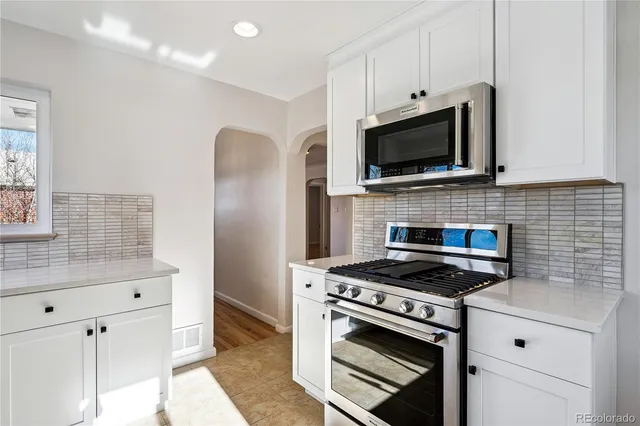 a kitchen with cabinets stainless steel appliances and a counter space