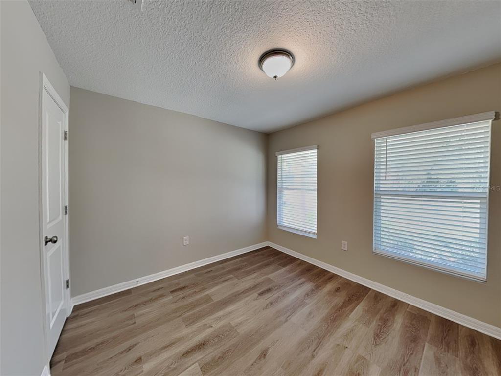 Undisclosed Address Spring Hill, FL 34608 - Photo 12 of 17 an empty room with wooden floor and windows