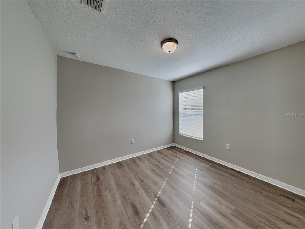 Undisclosed Address Spring Hill, FL 34608 - Photo 14 of 17 a view of an empty room with wooden floor and a window