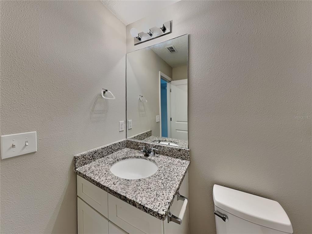 Undisclosed Address Spring Hill, FL 34608 - Photo 15 of 17 a bathroom with a granite countertop sink and a mirror
