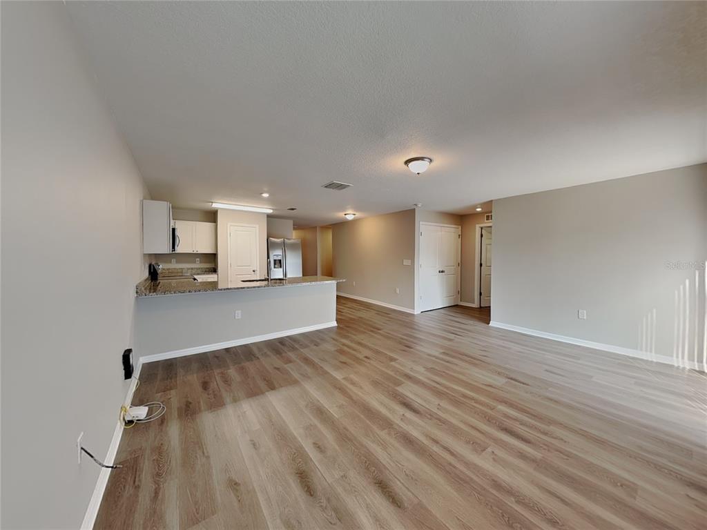 Undisclosed Address Spring Hill, FL 34608 - Photo 3 of 17 a view of kitchen and wooden floor