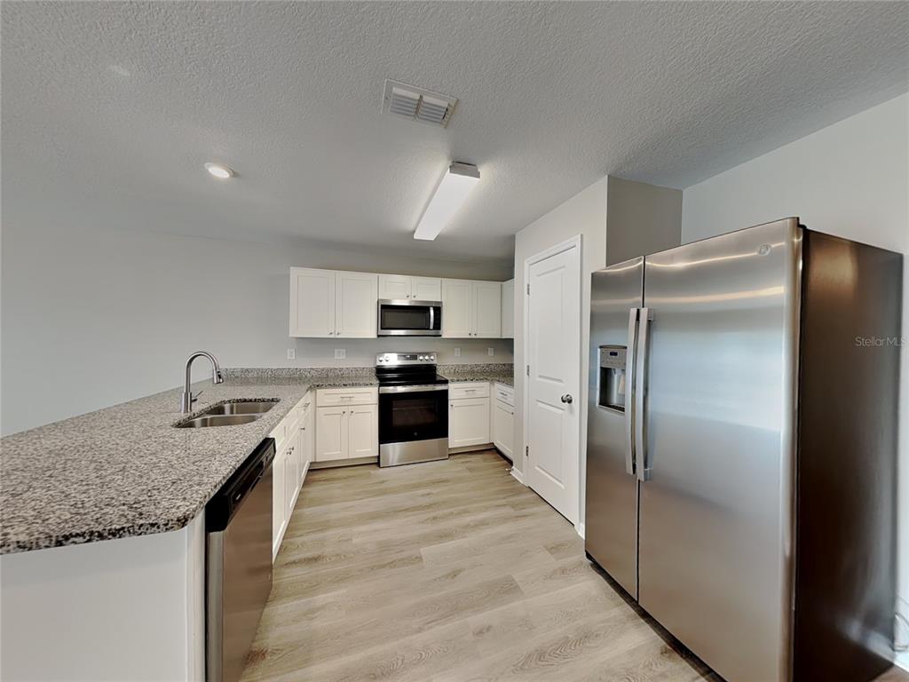Undisclosed Address Spring Hill, FL 34608 - Photo 4 of 17 a kitchen with granite countertop stainless steel appliances and refrigerator