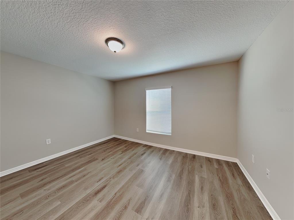 Undisclosed Address Spring Hill, FL 34608 - Photo 6 of 17 an empty room with wooden floor and windows