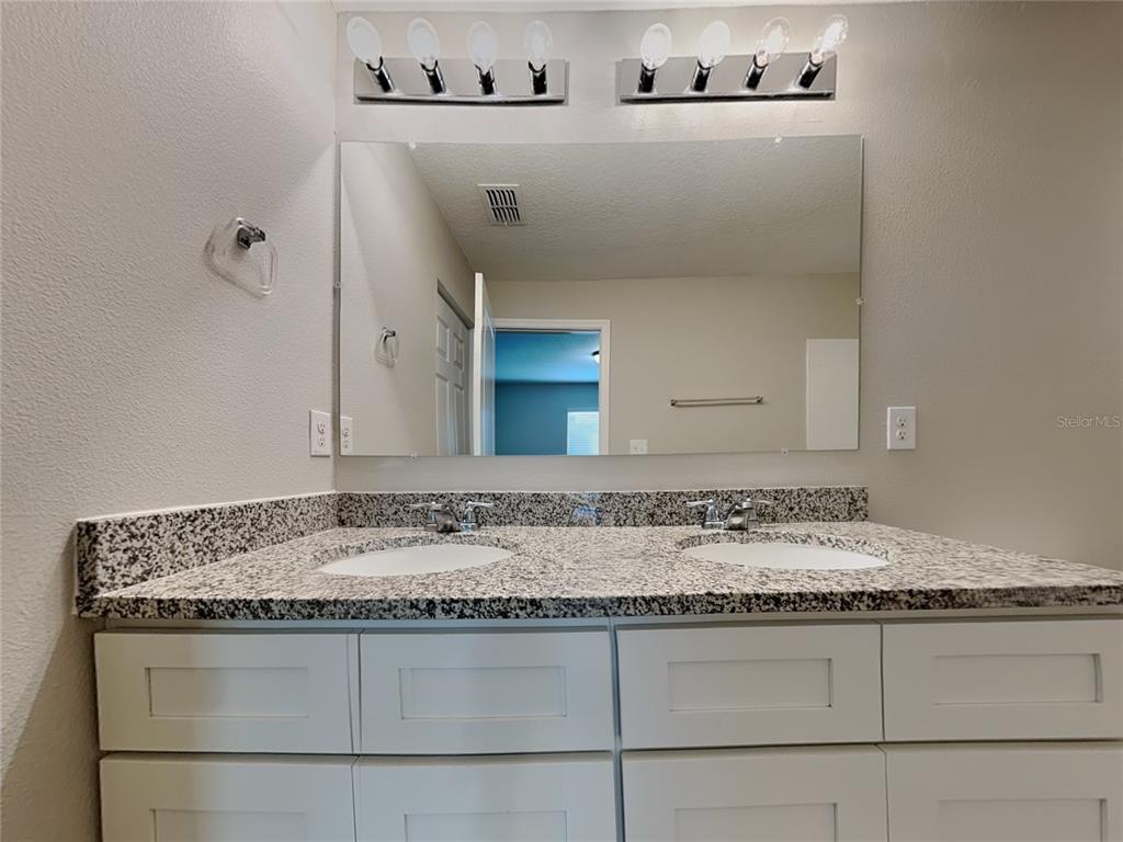 Undisclosed Address Spring Hill, FL 34608 - Photo 7 of 17 a bathroom with a granite countertop sink a mirror and vanity