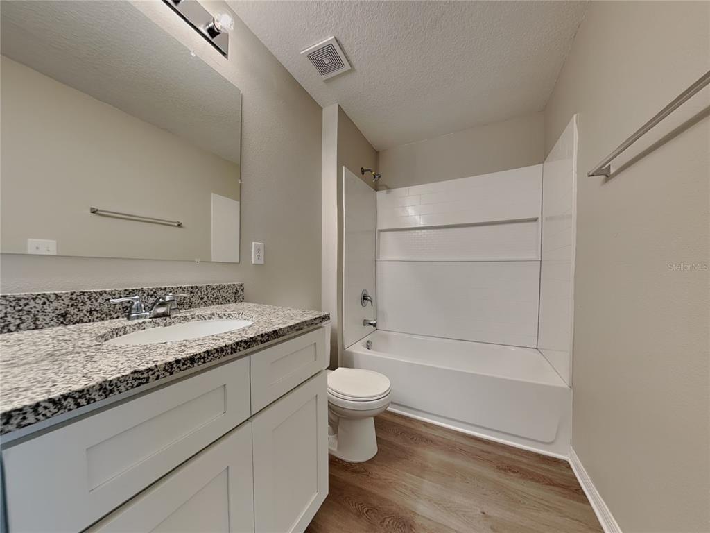 Undisclosed Address Spring Hill, FL 34608 - Photo 8 of 17 a bathroom with a granite countertop sink toilet and shower