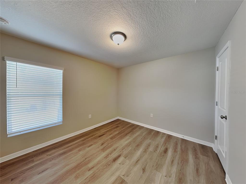Undisclosed Address Spring Hill, FL 34608 - Photo 9 of 17 wooden floor in an empty room with a window