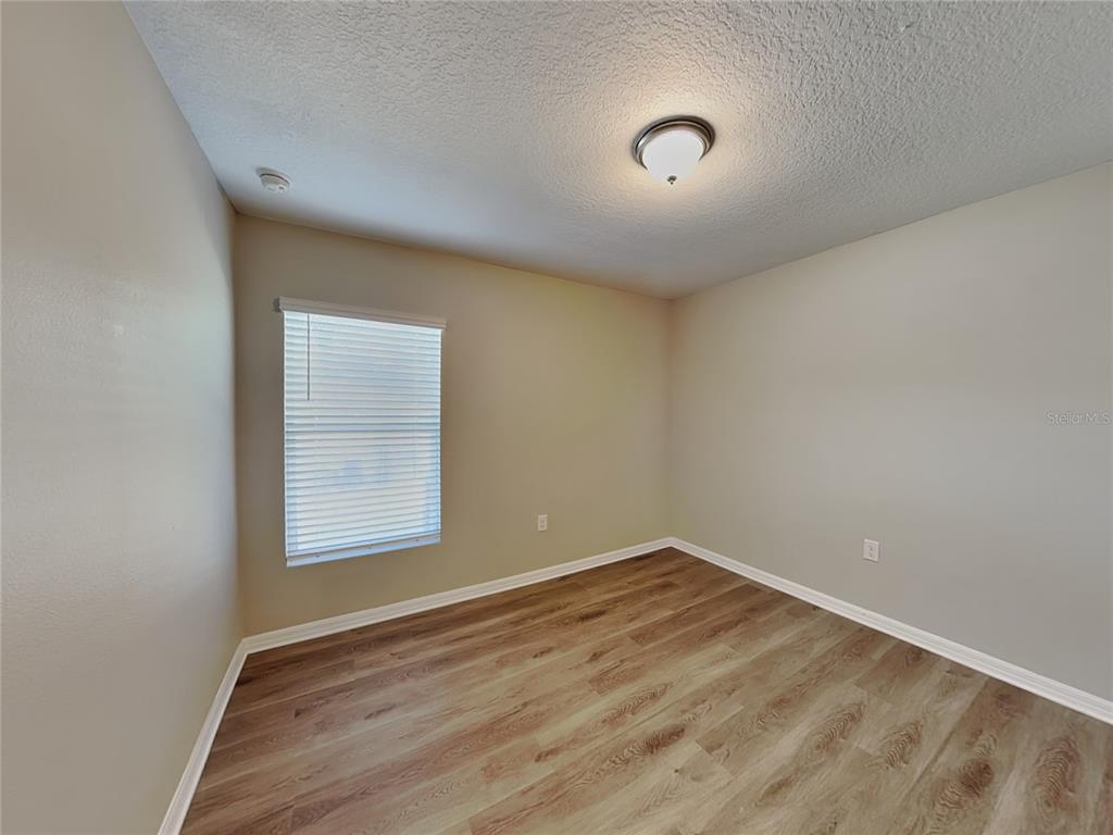 Undisclosed Address Spring Hill, FL 34608 - Photo 10 of 17 an empty room with wooden floor and windows