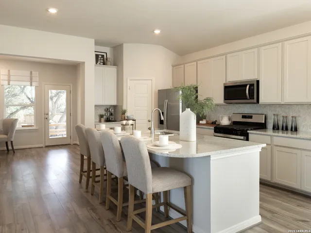 a kitchen with a dining table chairs and white appliances