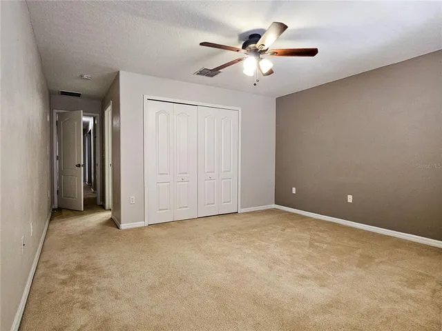 an empty room with chandelier fan