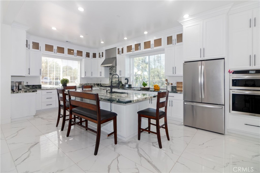 17423 Wicker Way Riverside, CA 92504 - Photo 16 of 66 a kitchen with refrigerator and chairs