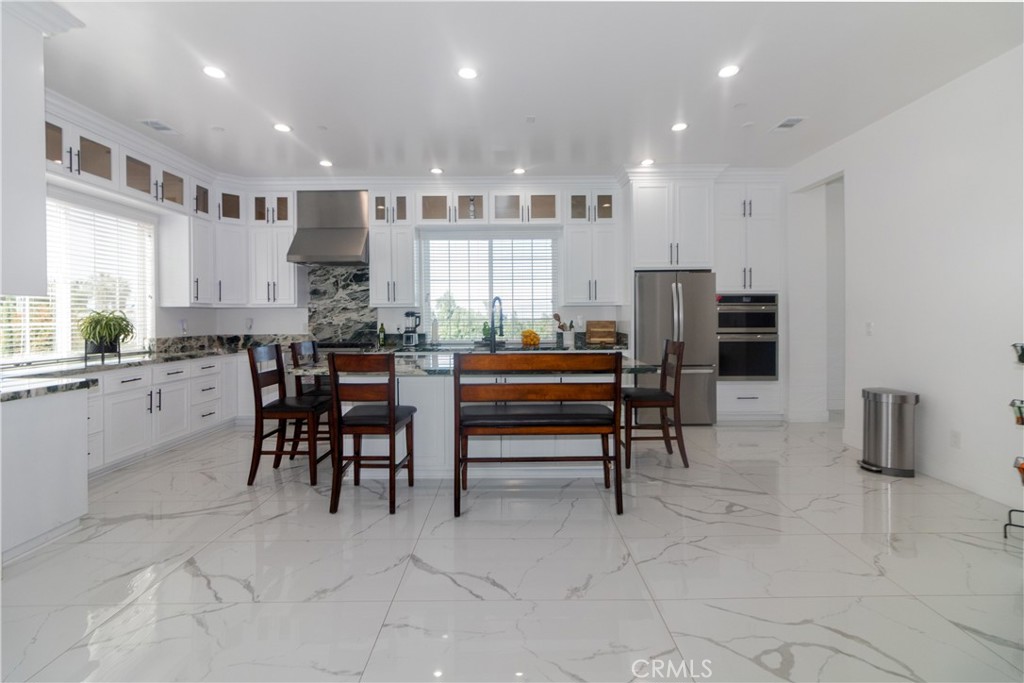 17423 Wicker Way Riverside, CA 92504 - Photo 17 of 66 a kitchen with stainless steel appliances kitchen island granite top and refrigerator