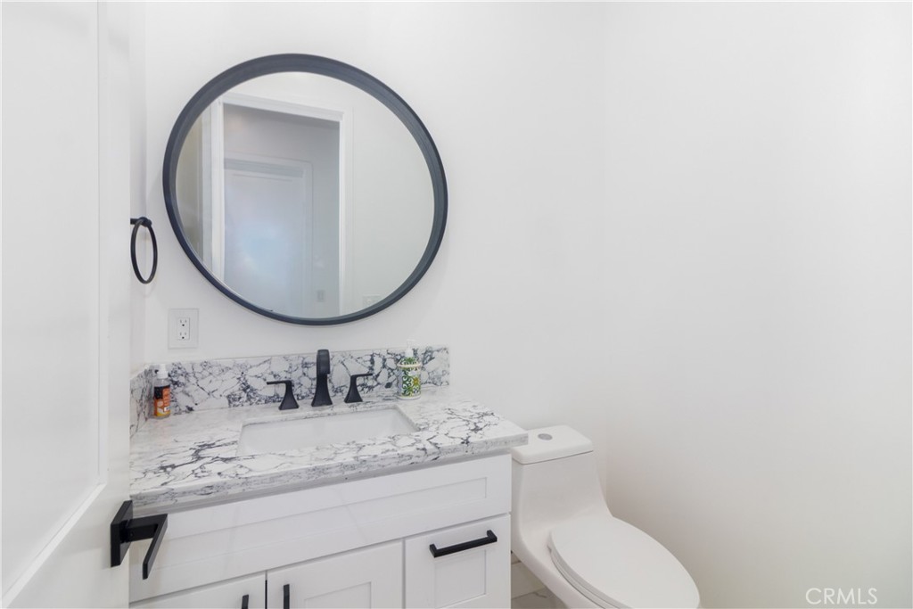 17423 Wicker Way Riverside, CA 92504 - Photo 19 of 66 a bathroom with a granite countertop toilet a sink and a mirror