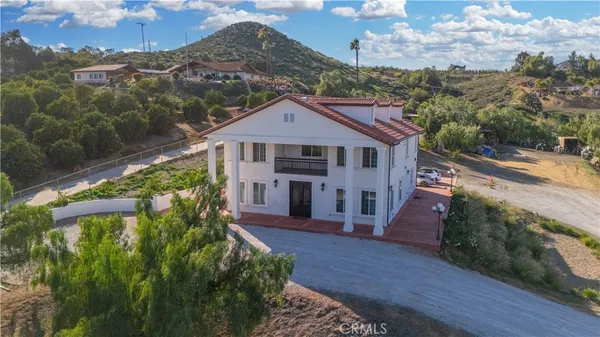 an aerial view of a house with a yard basket ball court and outdoor seating