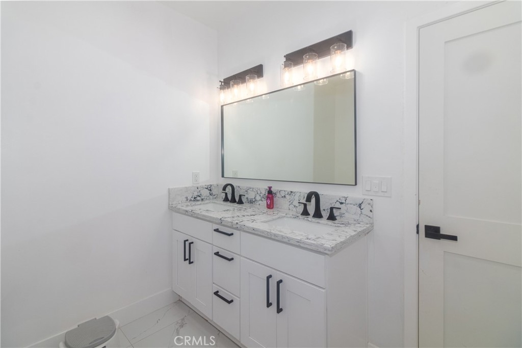 17423 Wicker Way Riverside, CA 92504 - Photo 31 of 66 a bathroom with a granite countertop sink and a mirror