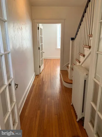 a view of a hallway with wooden floor and staircase